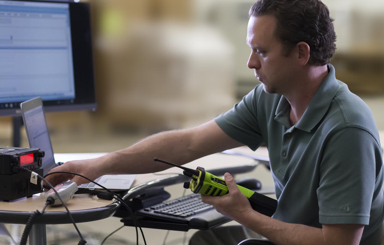 integrating two-way radios. Man holding a Motorola solutions radio.