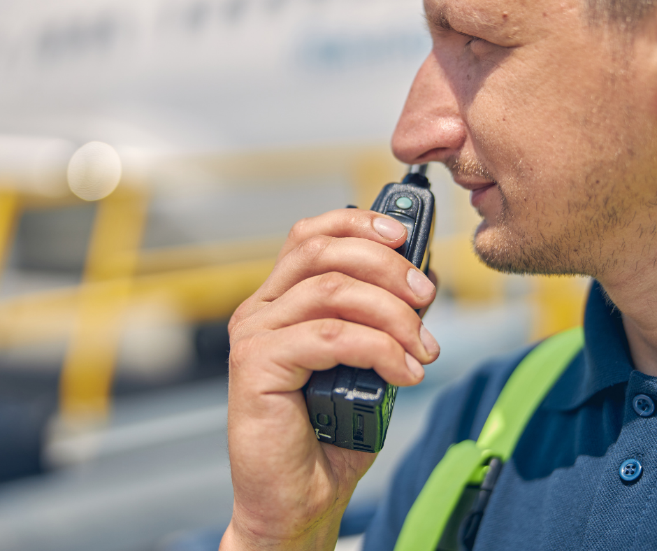 Wide area vs on-site two-way radios. Man holding two-way radio to speak into.
