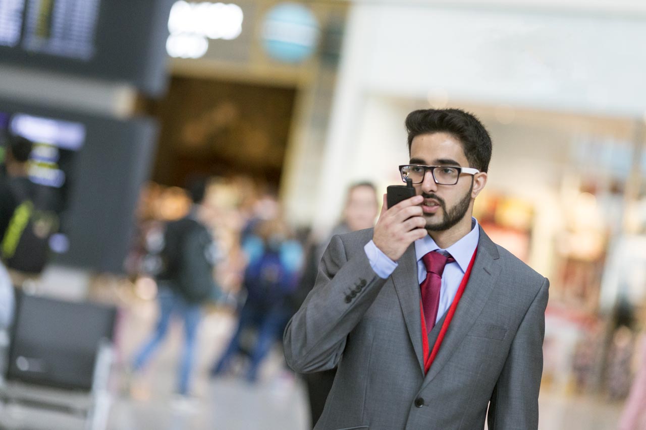 features of two-way radios. Man in gray suit holding a tetra two-way radio from motorola solutions